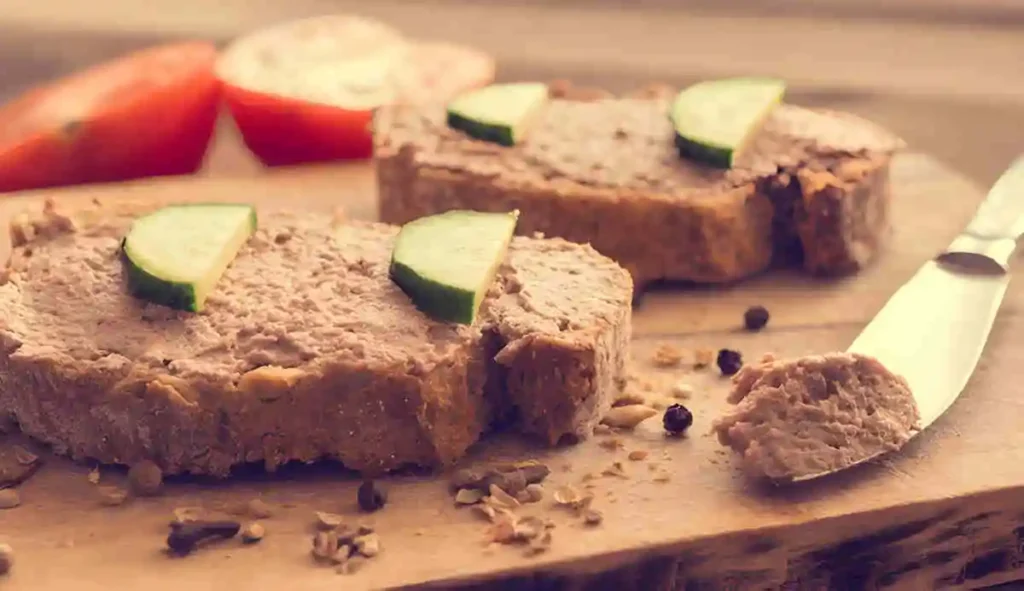 Slices of a homemade salmon loaf on toasted bread, garnished with cucumber slices.